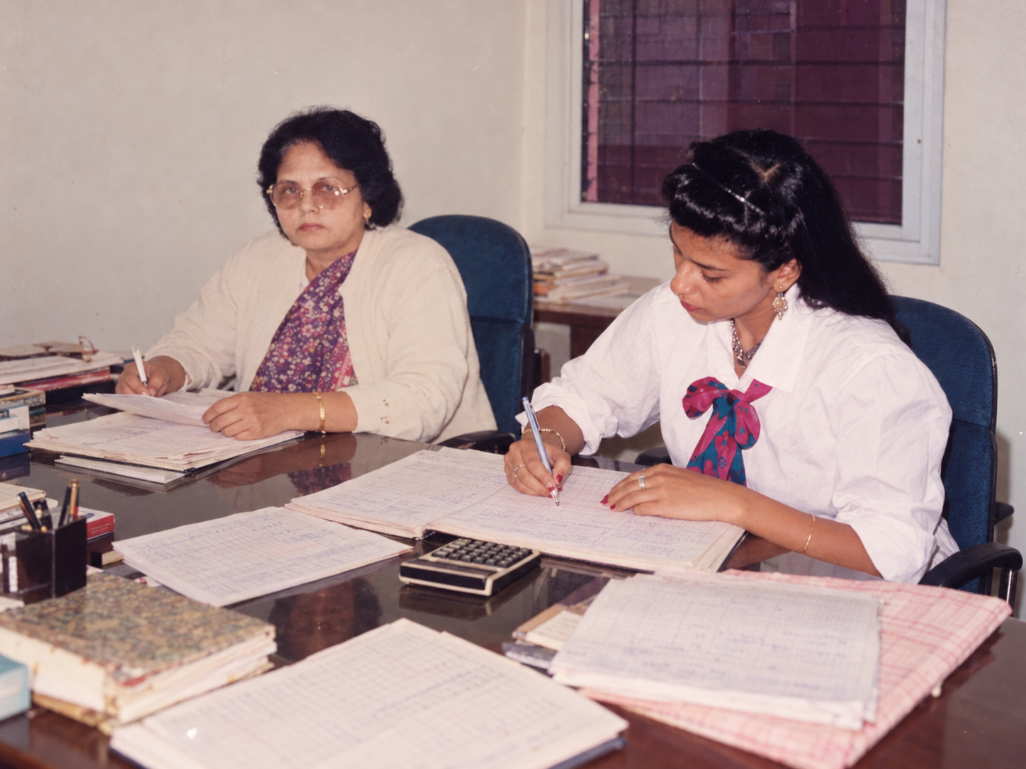 Reconstructed composite of Mrs. Kusum Gupta and her daughter working at a shared office table